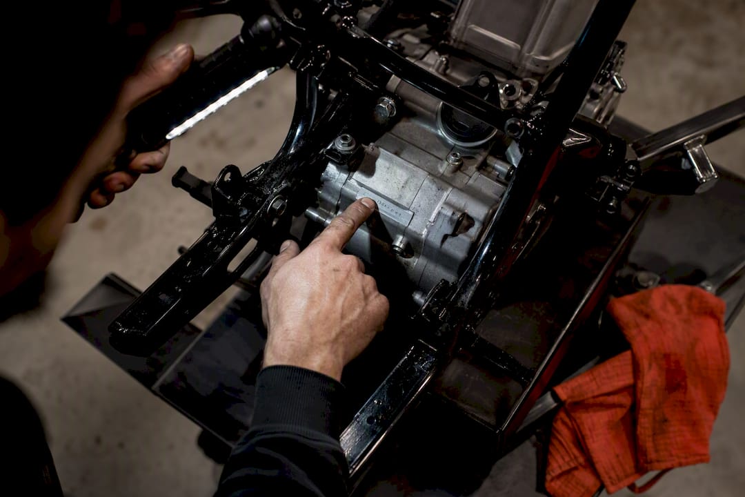 Mechanic examining ATV engine serial marking