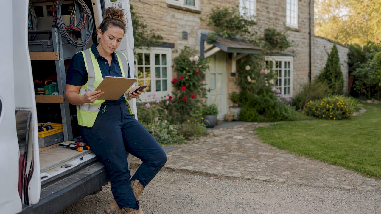 Electrician reviewing credentials outdoors by van