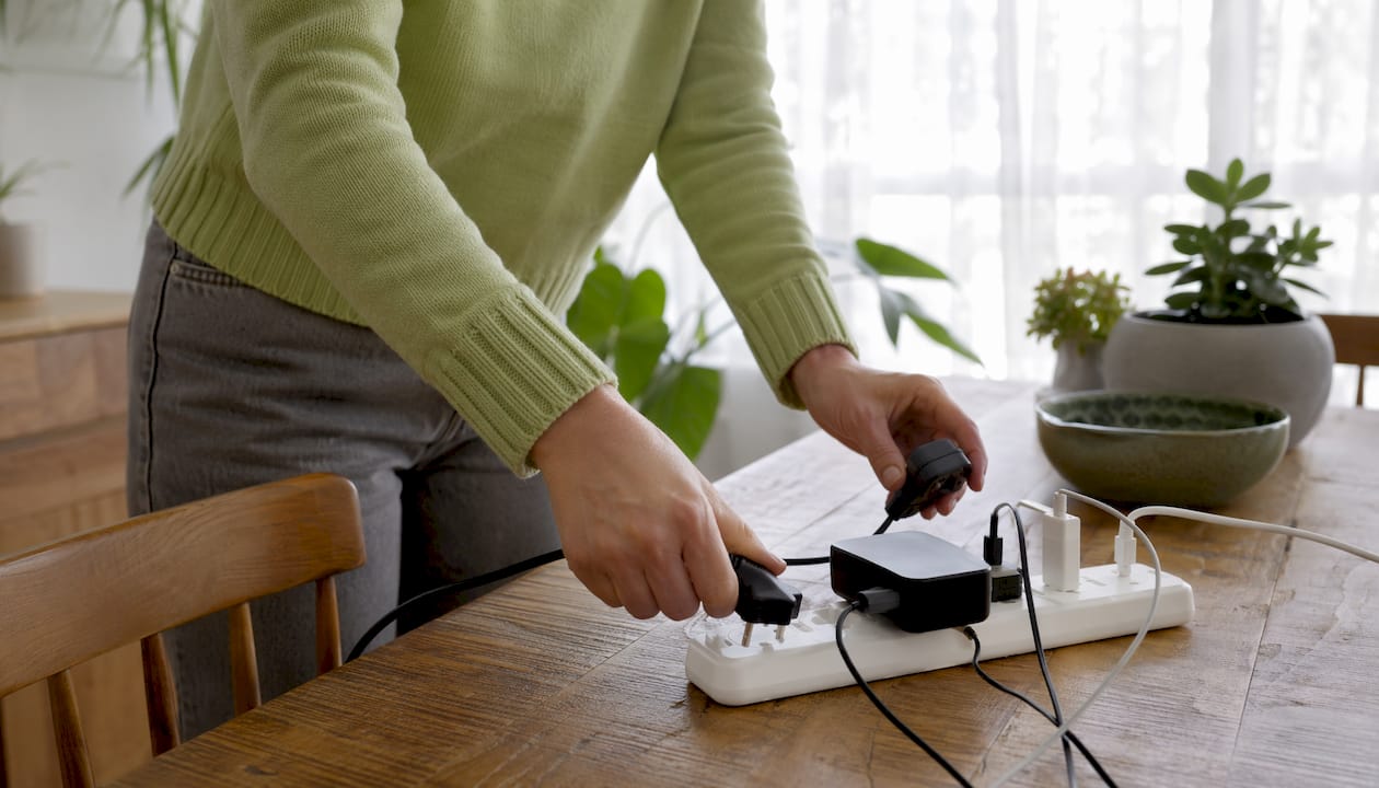 Hands unplugging overloaded extension socket