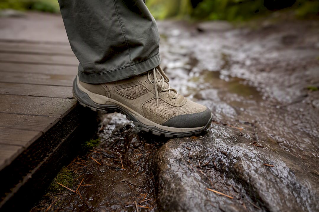 Hiker stepping from boardwalk onto wet rock