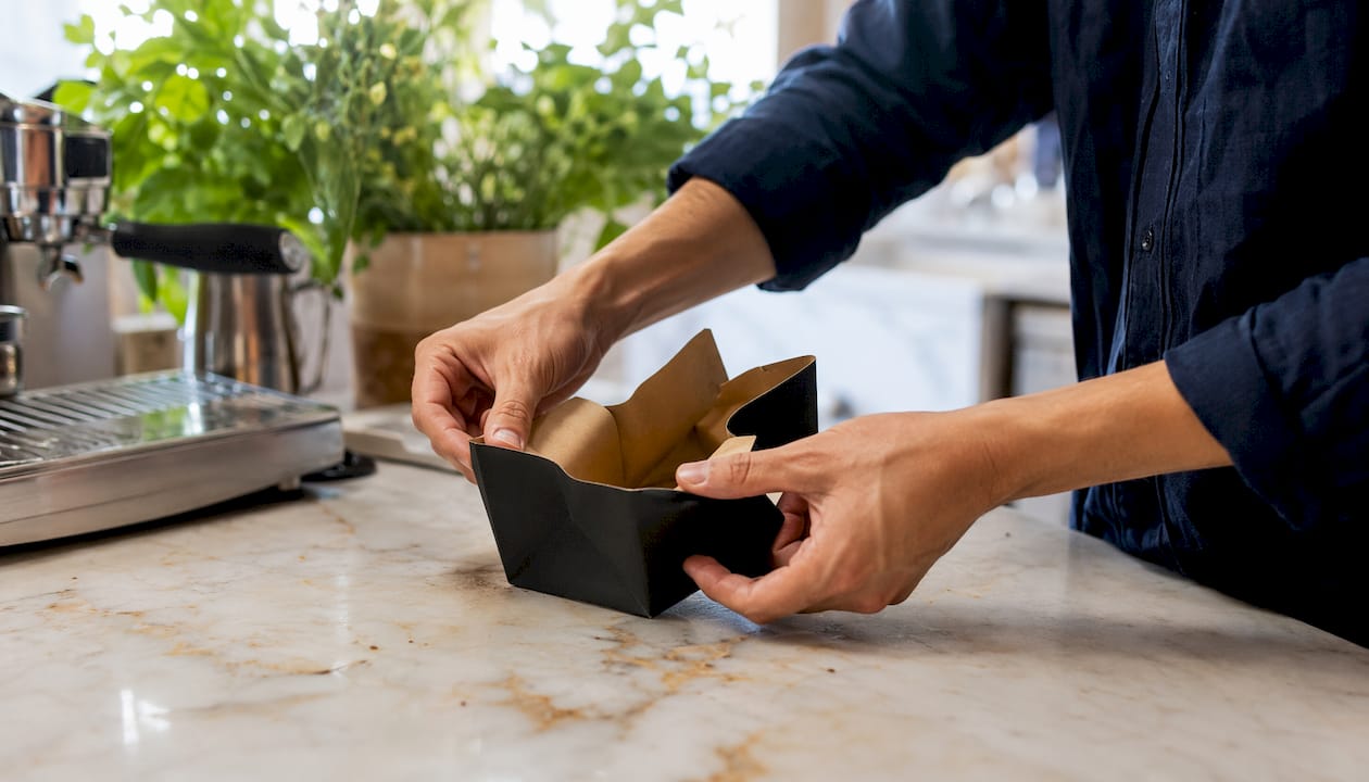 Hands opening SOS bag gussets in cafe