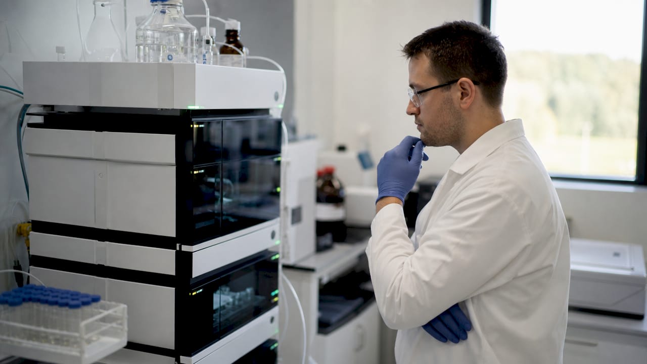 Technician operating HPLC machine for peptide testing