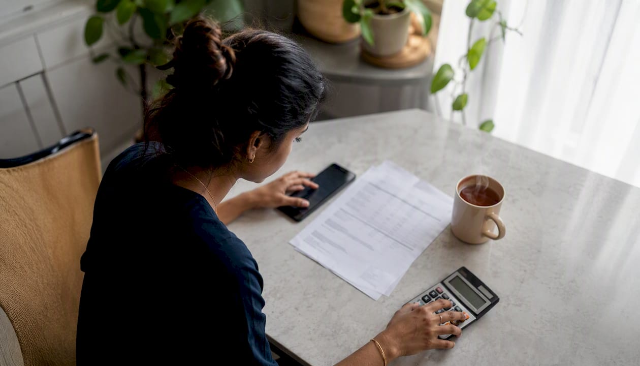 Hands calculating personal loan costs with contractor quote