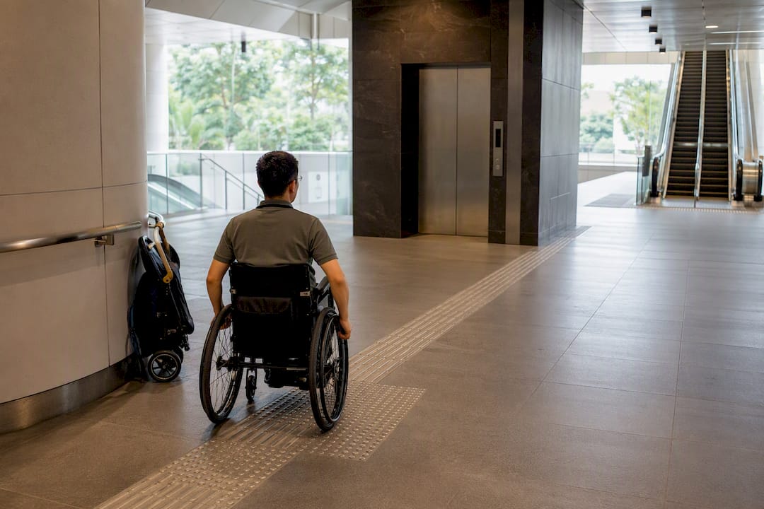 Wheelchair user approaching accessible station lift