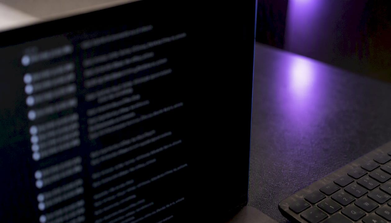 Blurred audit trail logs on dark computer screen