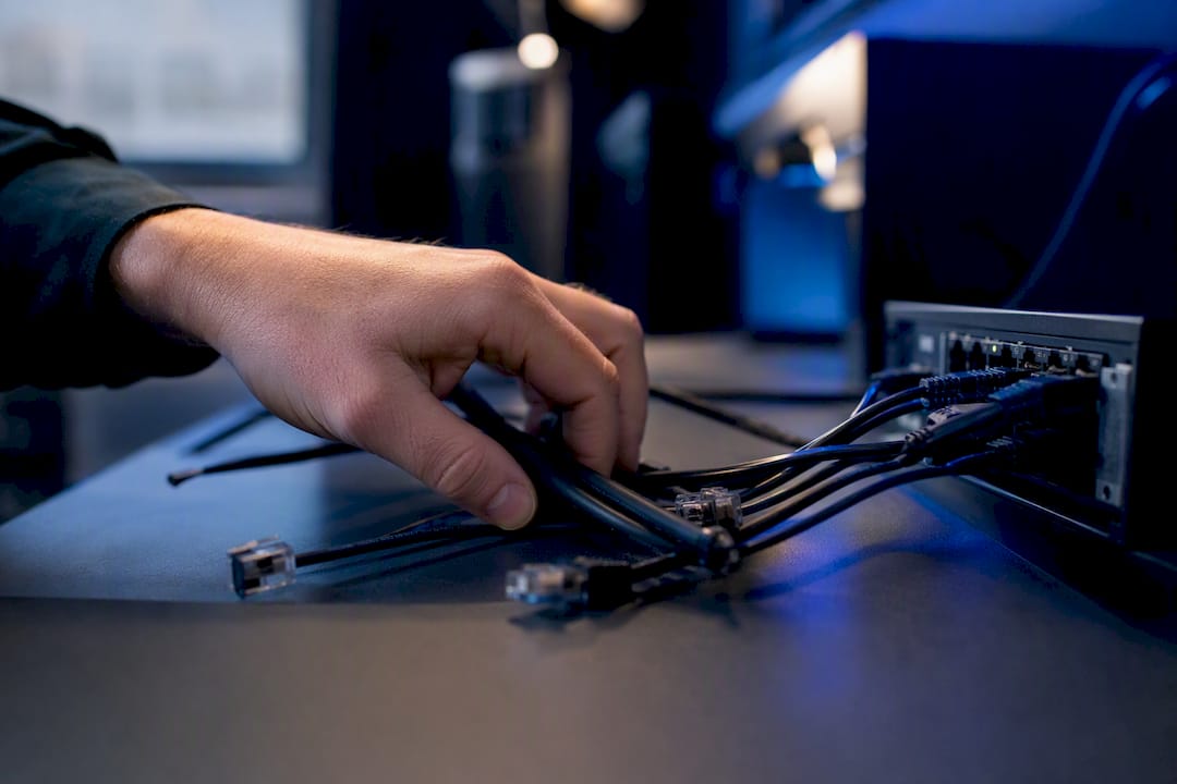 Hand adjusting network cables on desk