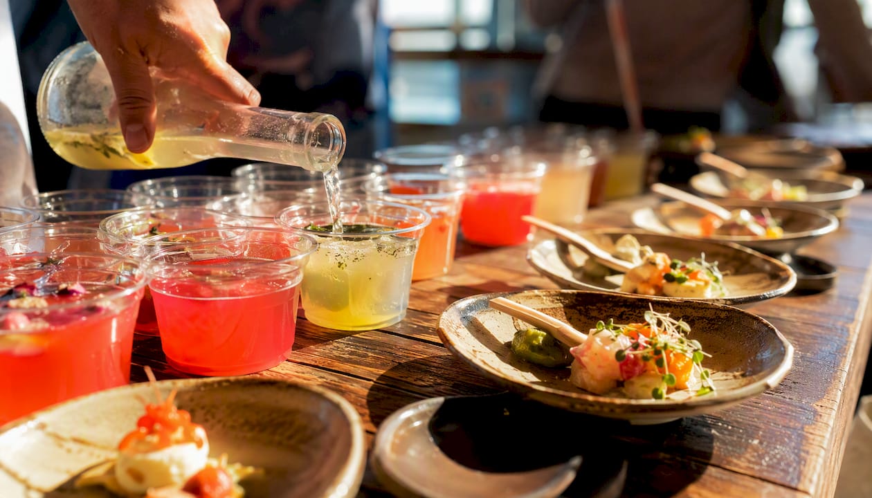 Hand pouring sample beverage at tasting bar
