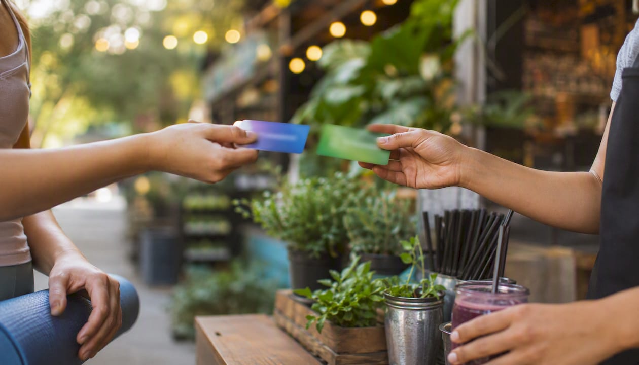 Hands exchanging discount cards between local businesses