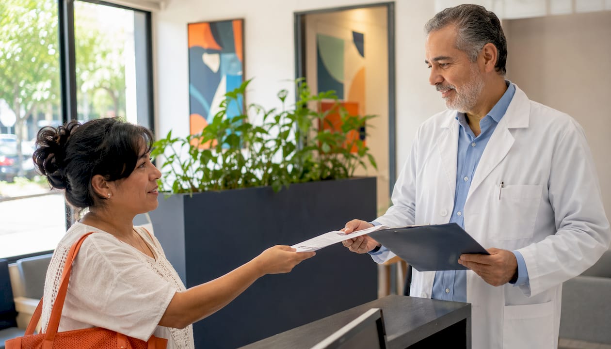 Patient handing medical certificate to doctor