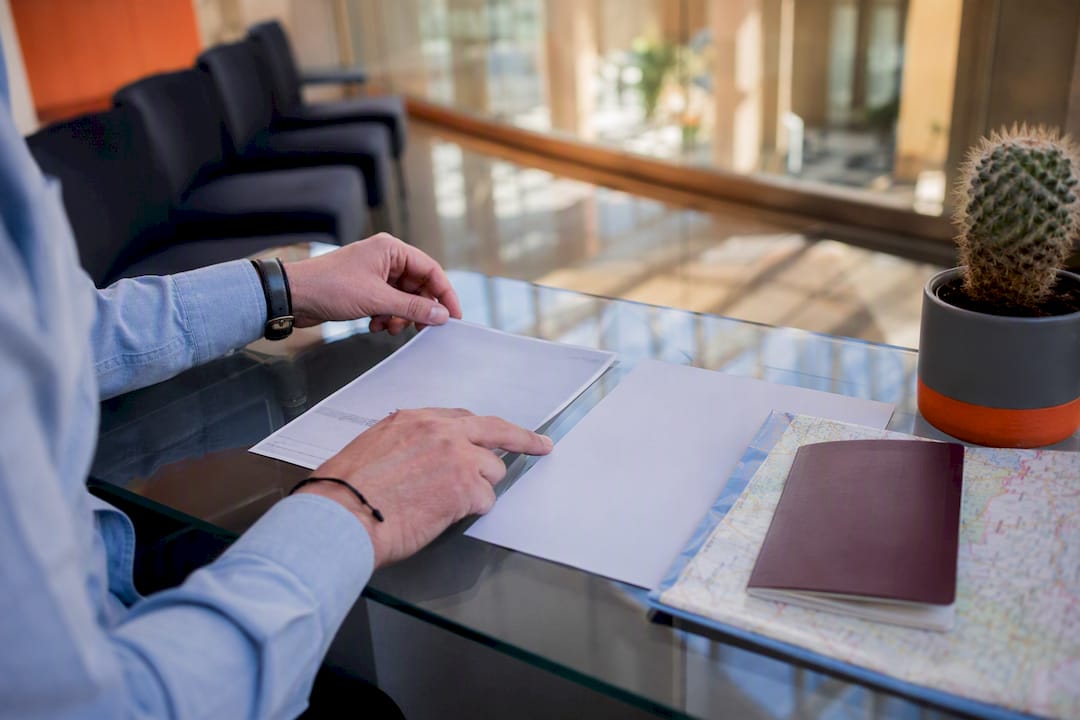 Hand arranging TIE renewal documents on table