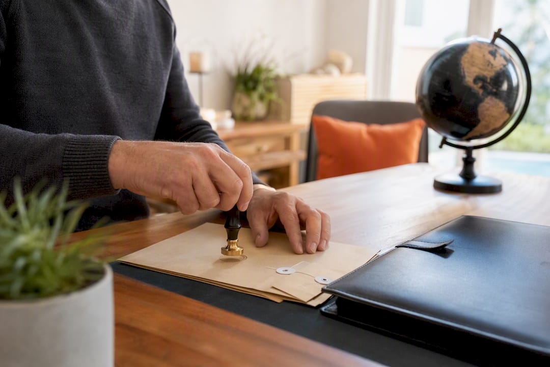 Hands stamping official visa documents