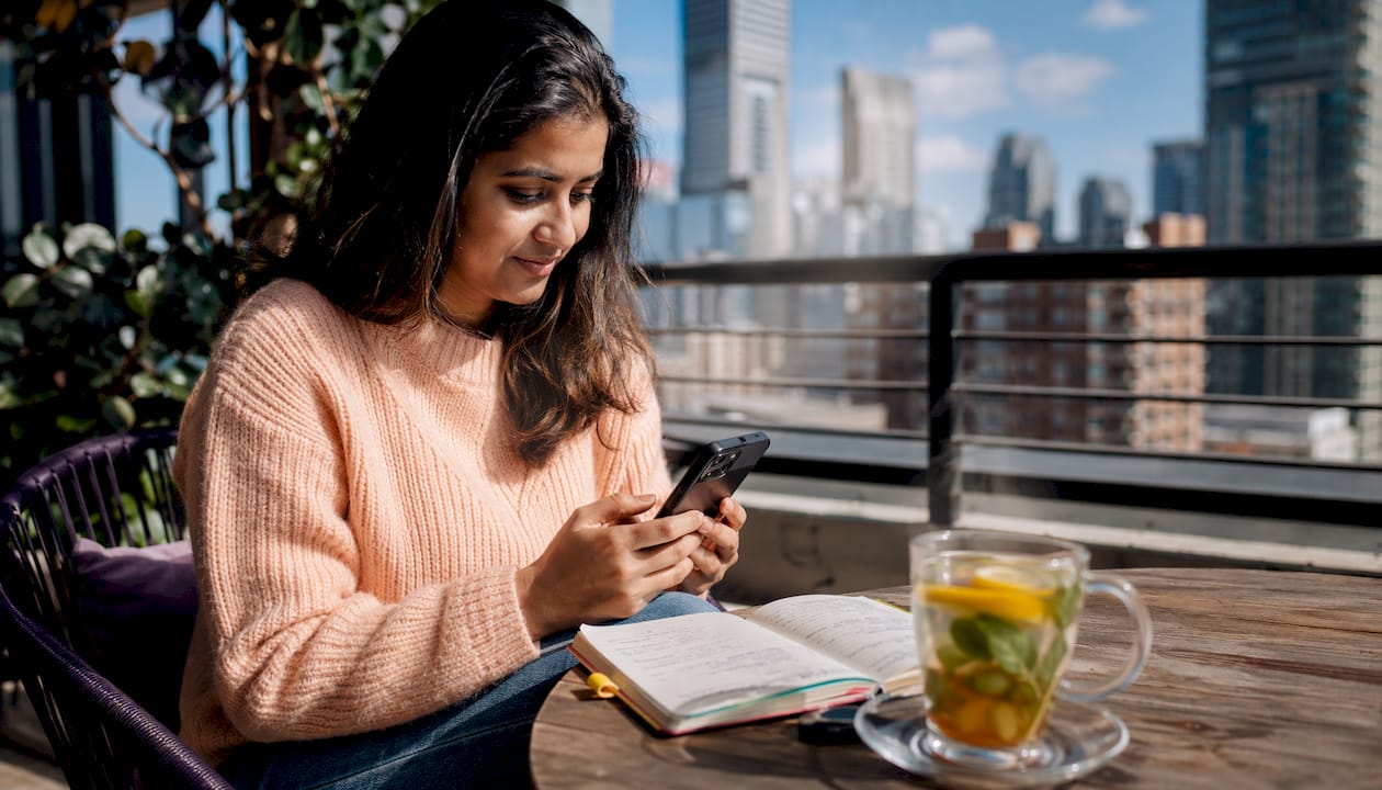 Hands holding phone with lead notification outdoors