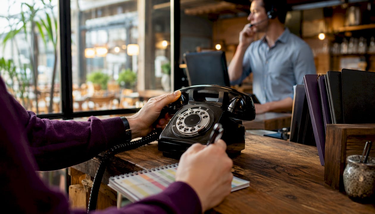 Hands noting call details at restaurant and clinic desks