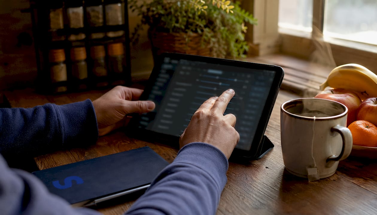 Hands adjusting Amazon PPC bids on tablet