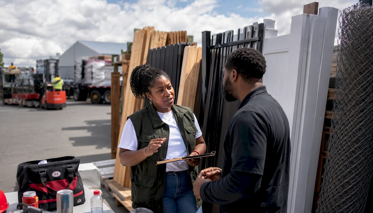 Female contractor reviewing fence materials outdoors