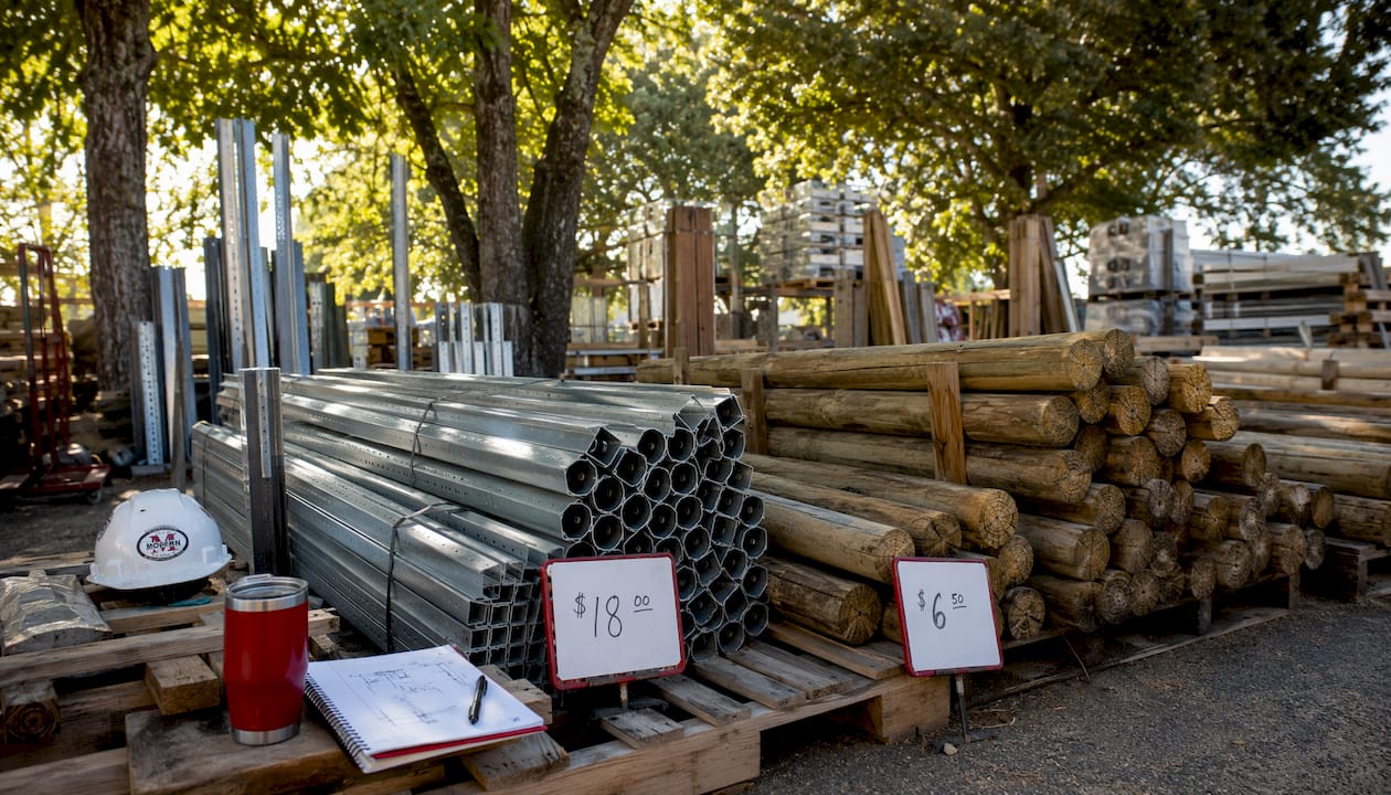 Steel and wooden fence posts with price tags
