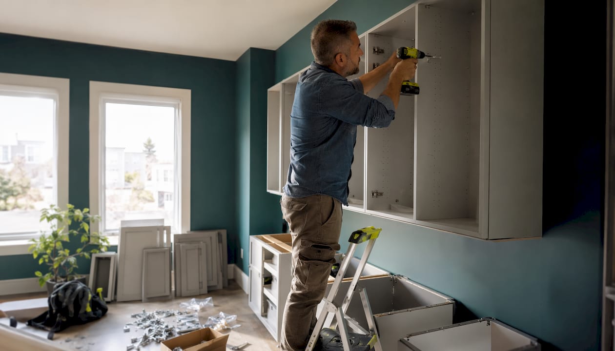 Installer assembling RTA kitchen cabinets