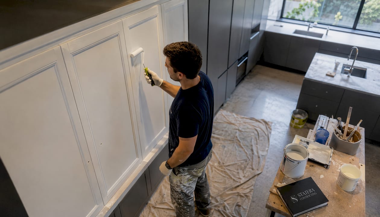 Man painting kitchen cabinet doors
