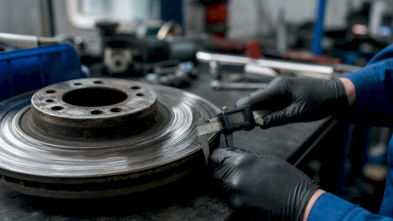 Close-up of warped brake rotor and torque wrench