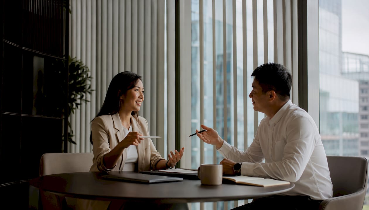 Office managers near large windows with vertical blinds