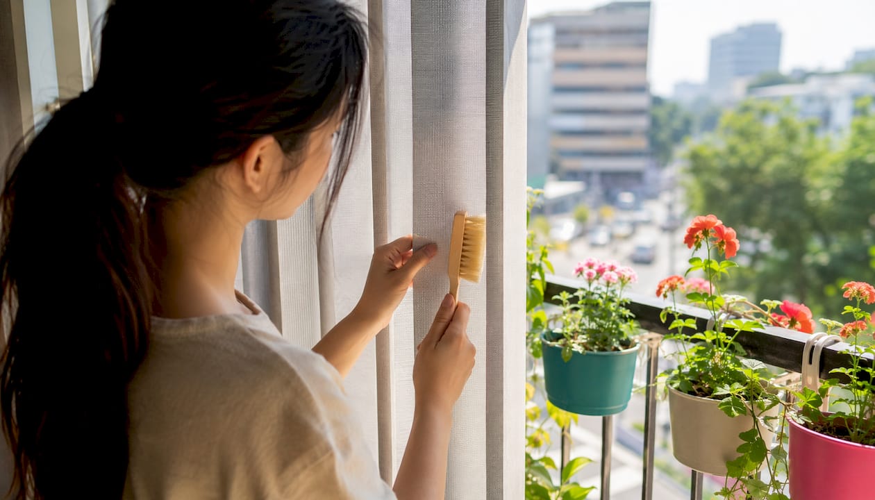 Hands cleaning fabric vertical blinds in home