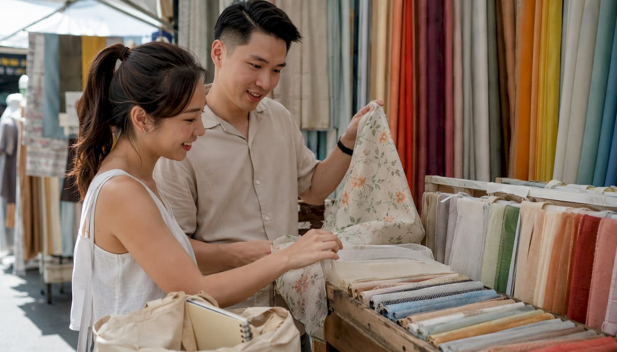 Hands examining curtain fabric swatches closely