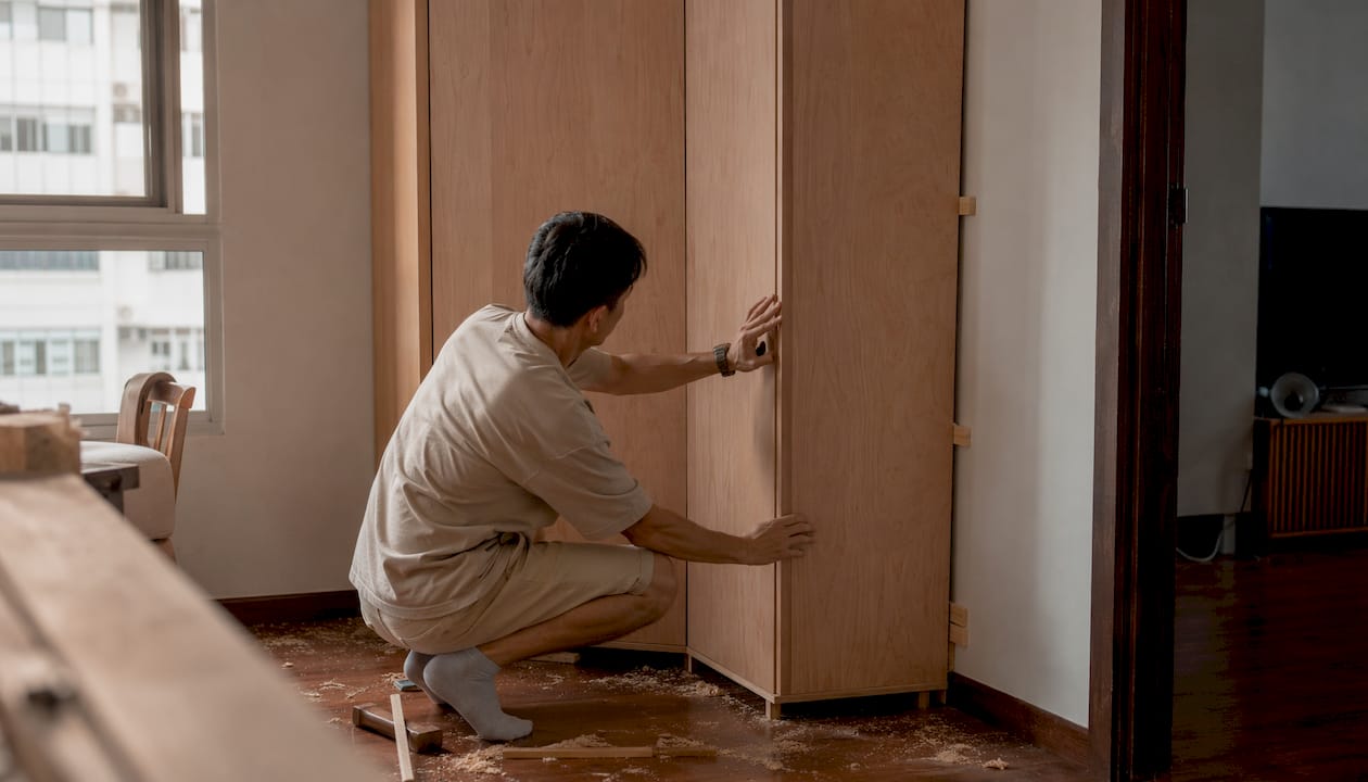 Hands fitting custom built-in cabinet in HDB corner