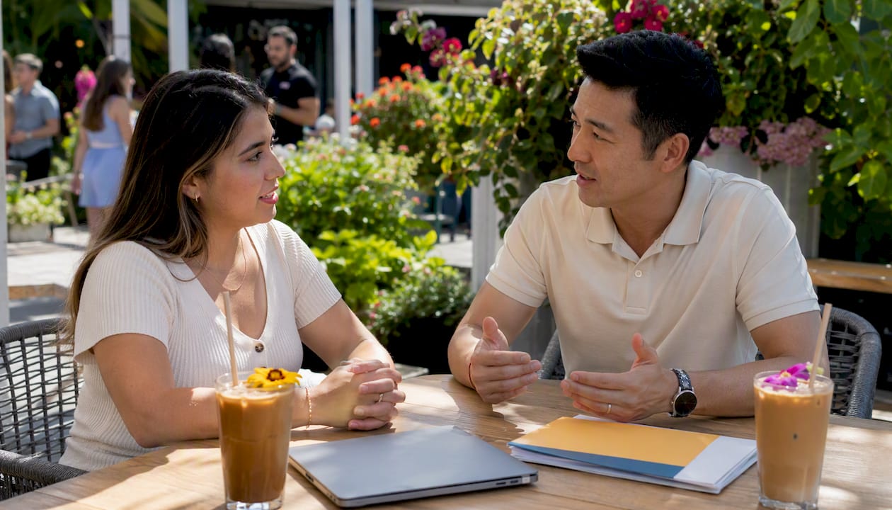 Coworkers discussing onboarding at cafe table