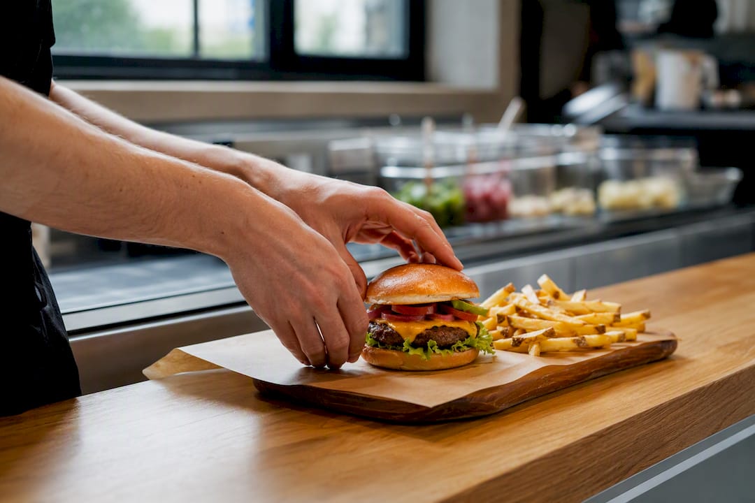 Hands assembling burger combo meal