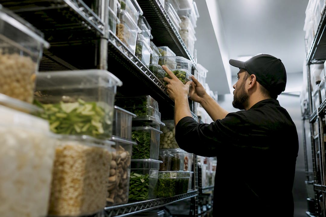 Hands organizing restaurant kitchen inventory