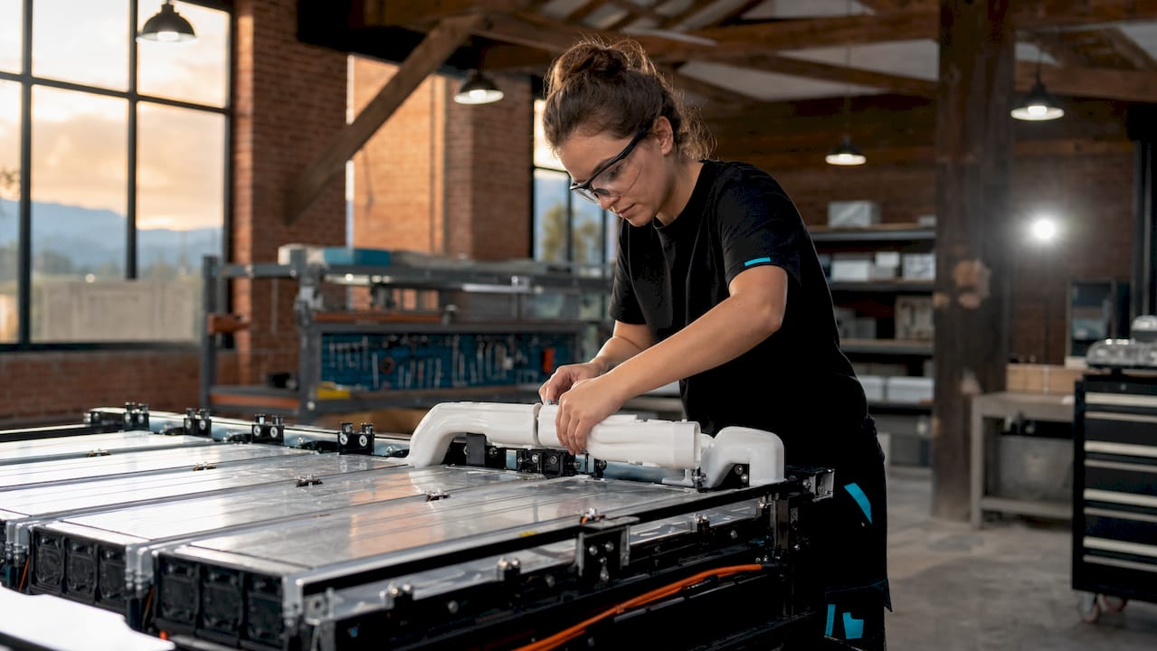 Technician assembling air cooling ducts on EV battery module