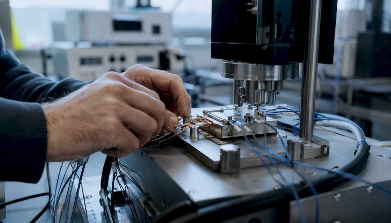 Technician adjusting thermal sensors on interface sample