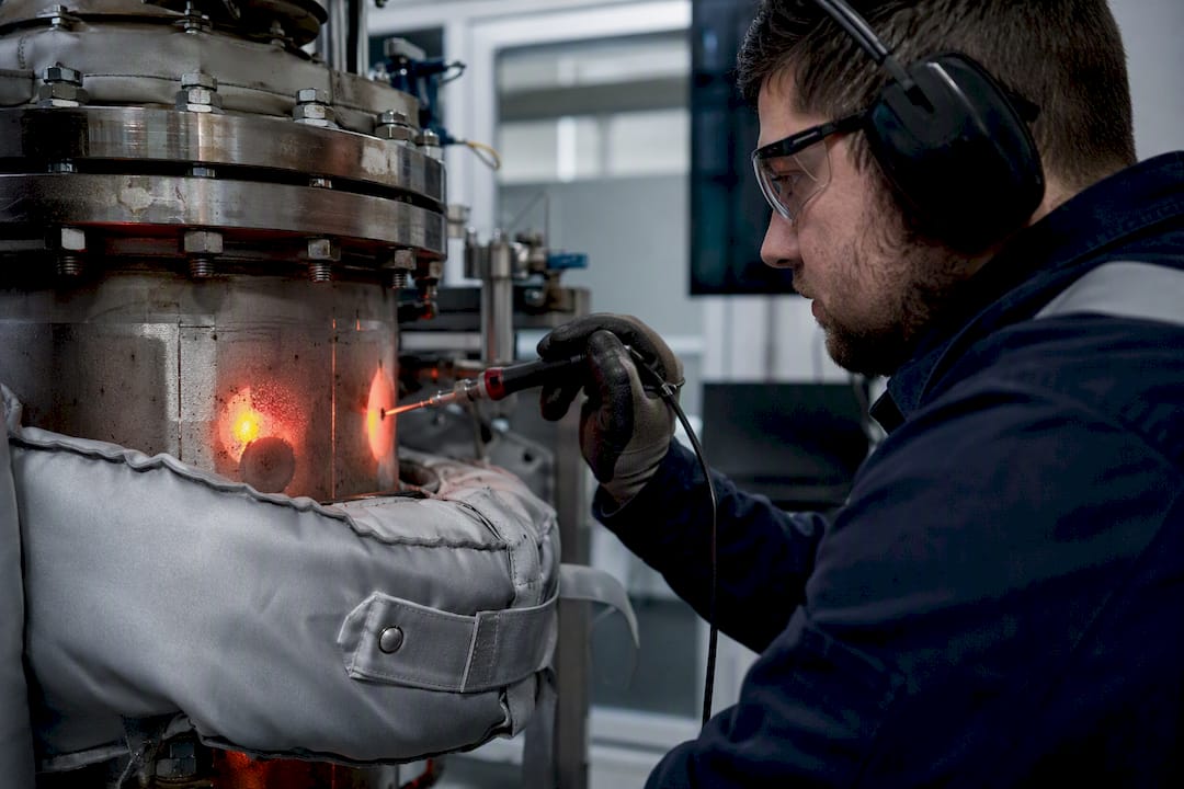 Engineer measuring heat on pressure vessel jacket