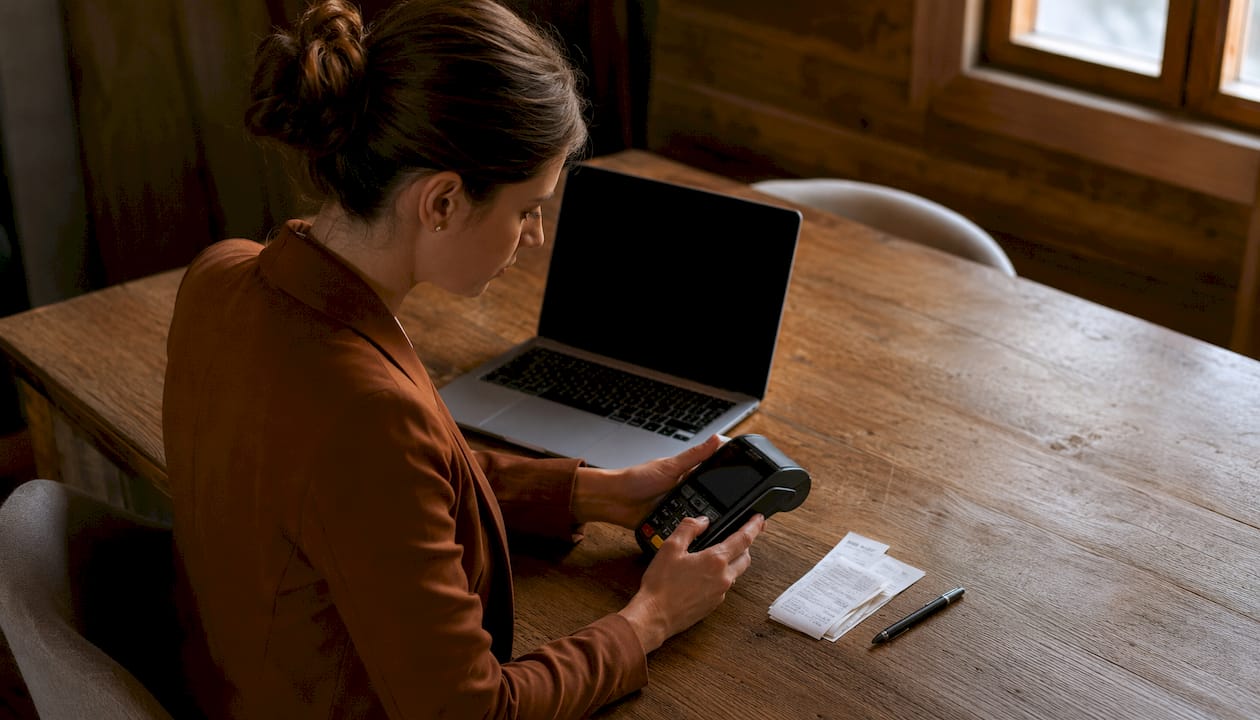 Una donna effettua un pagamento tracciabile direttamente allo sportello dell’ufficio.