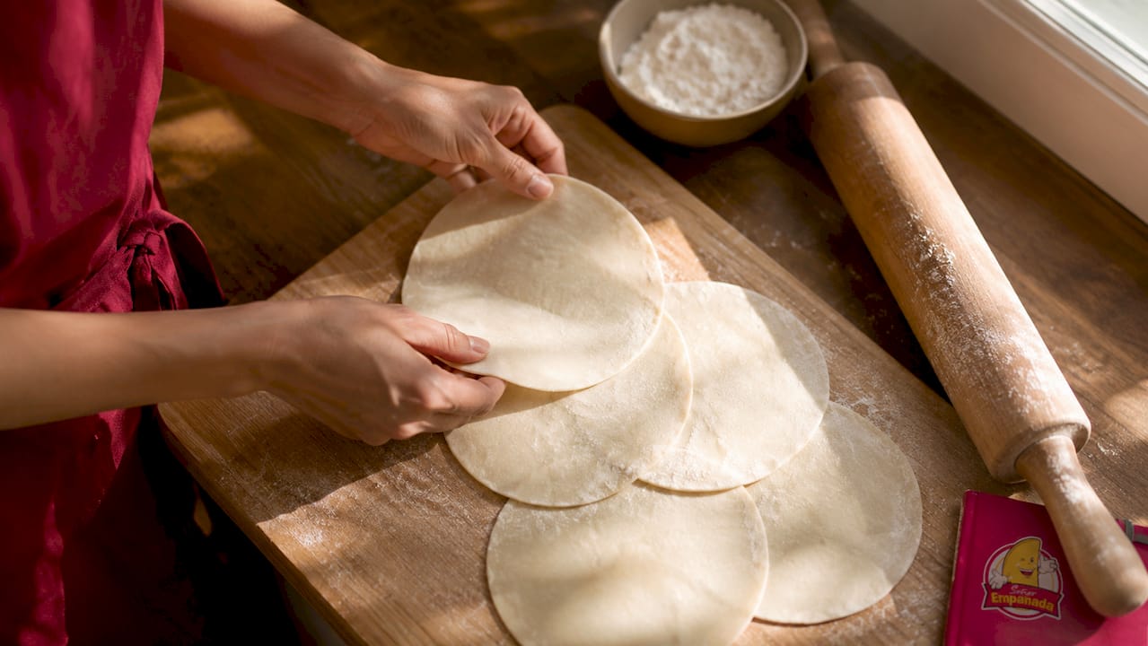 Hands placing pie crust rounds on baking sheet