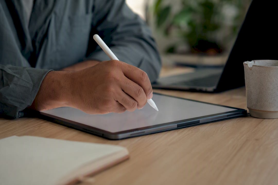 Hands taking notes on digital tablet
