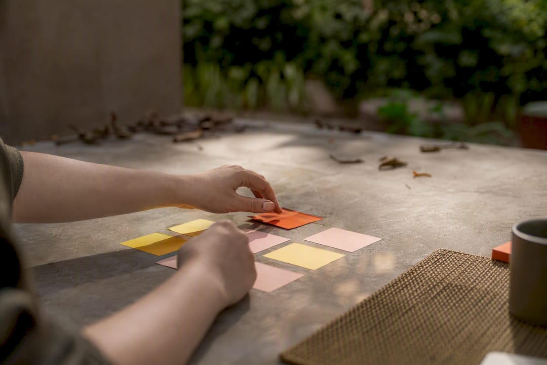 Hands organizing decision markers on table