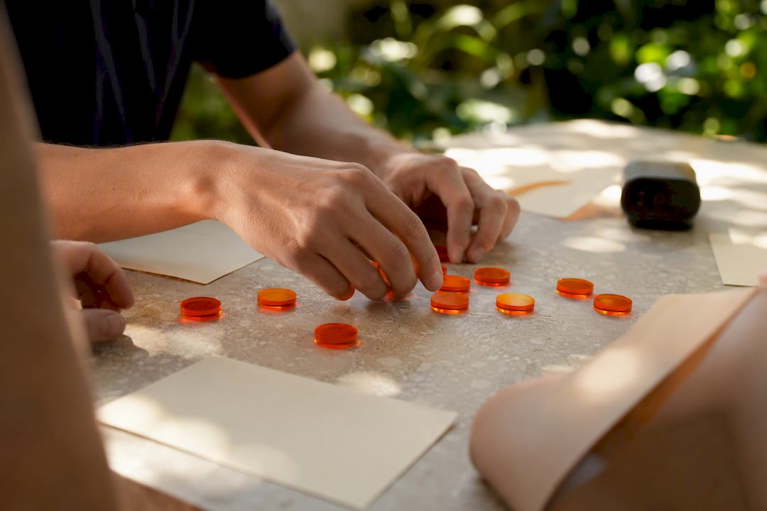 Hands arranging consent tokens on table