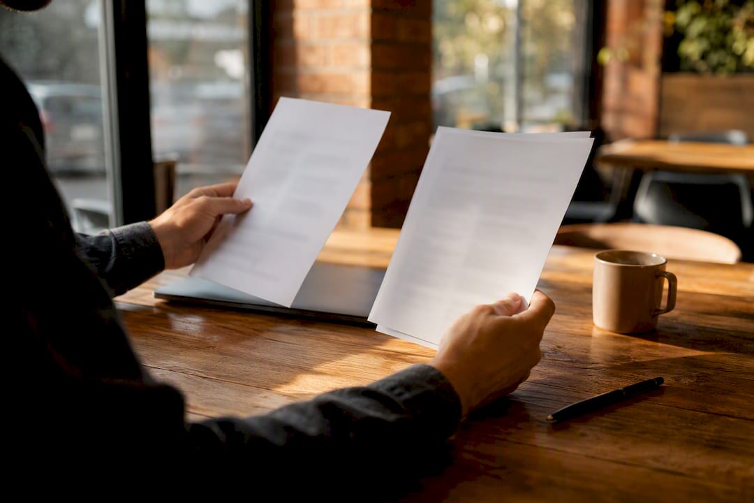 Hands comparing expert answers on papers