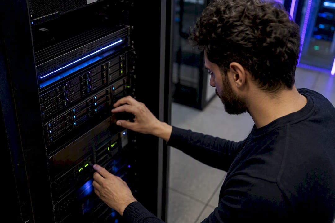 Mani al lavoro sulla configurazione del pannello di rete di un server all’interno di un rack.