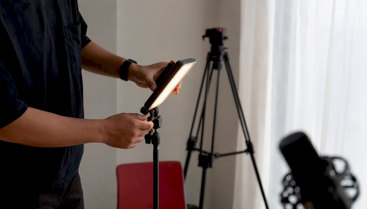 Hands adjusting video light for promo shoot