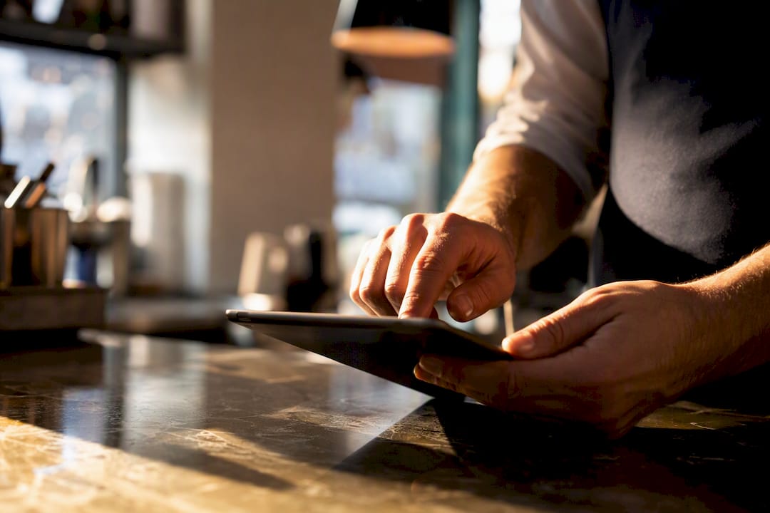 Hands arranging menu sheets at restaurant desk