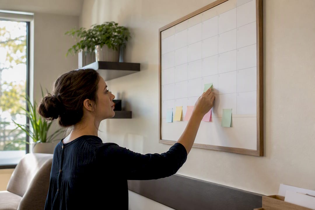 Staff placing reminder note on calendar wall