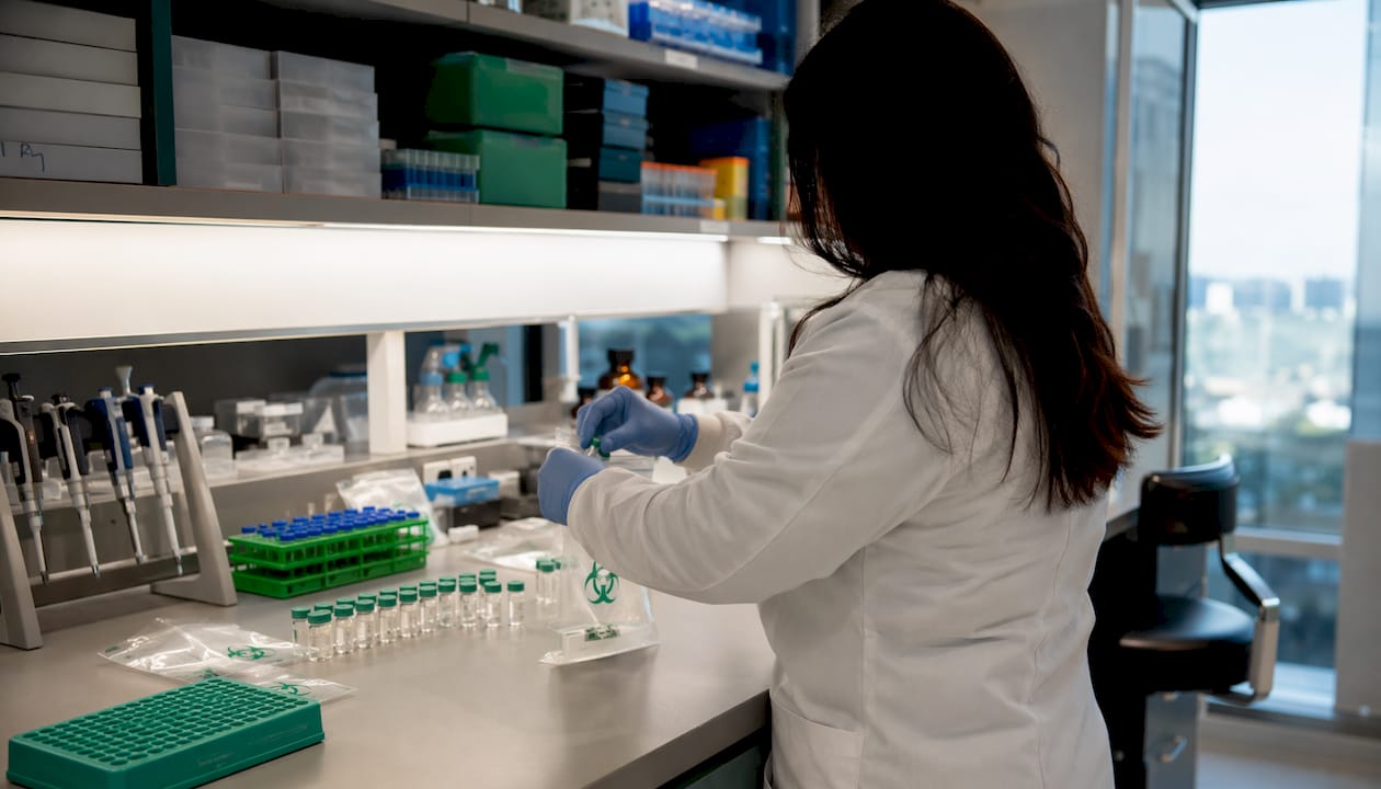 Technician packaging peptide vials in lab