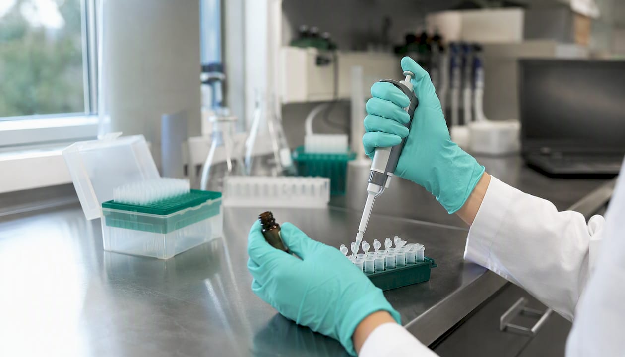 Hands pipetting peptide aliquots in lab