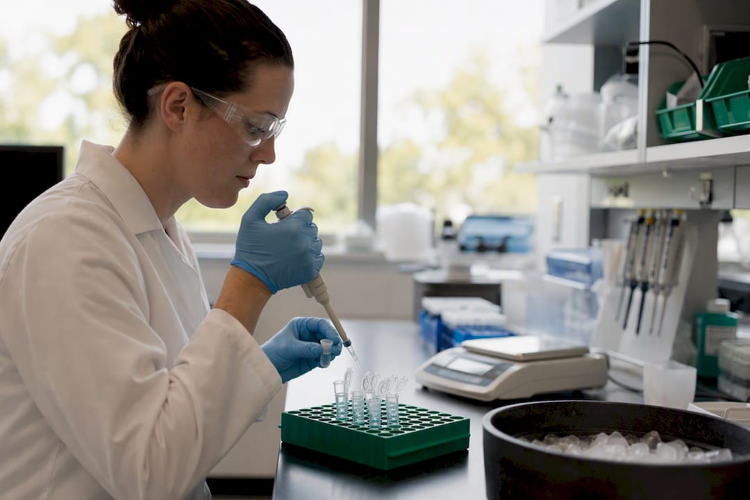 Hands aliquoting peptide into tubes