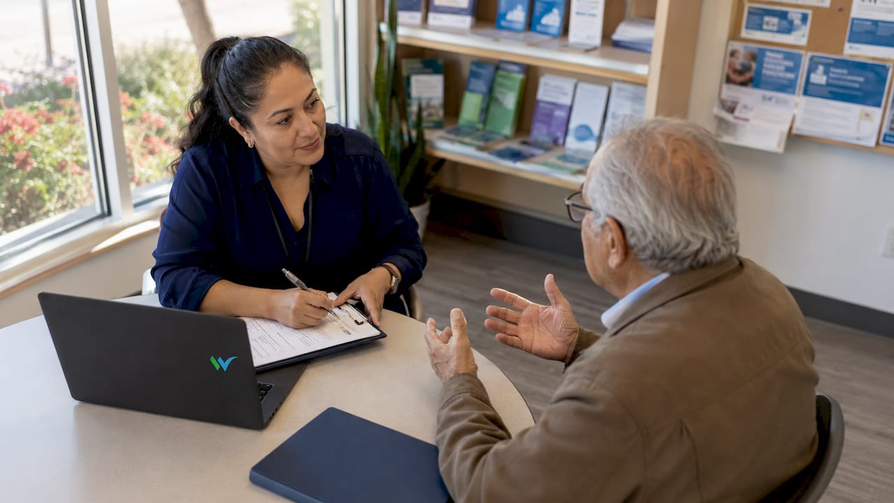 Community health worker with elderly client in home setting