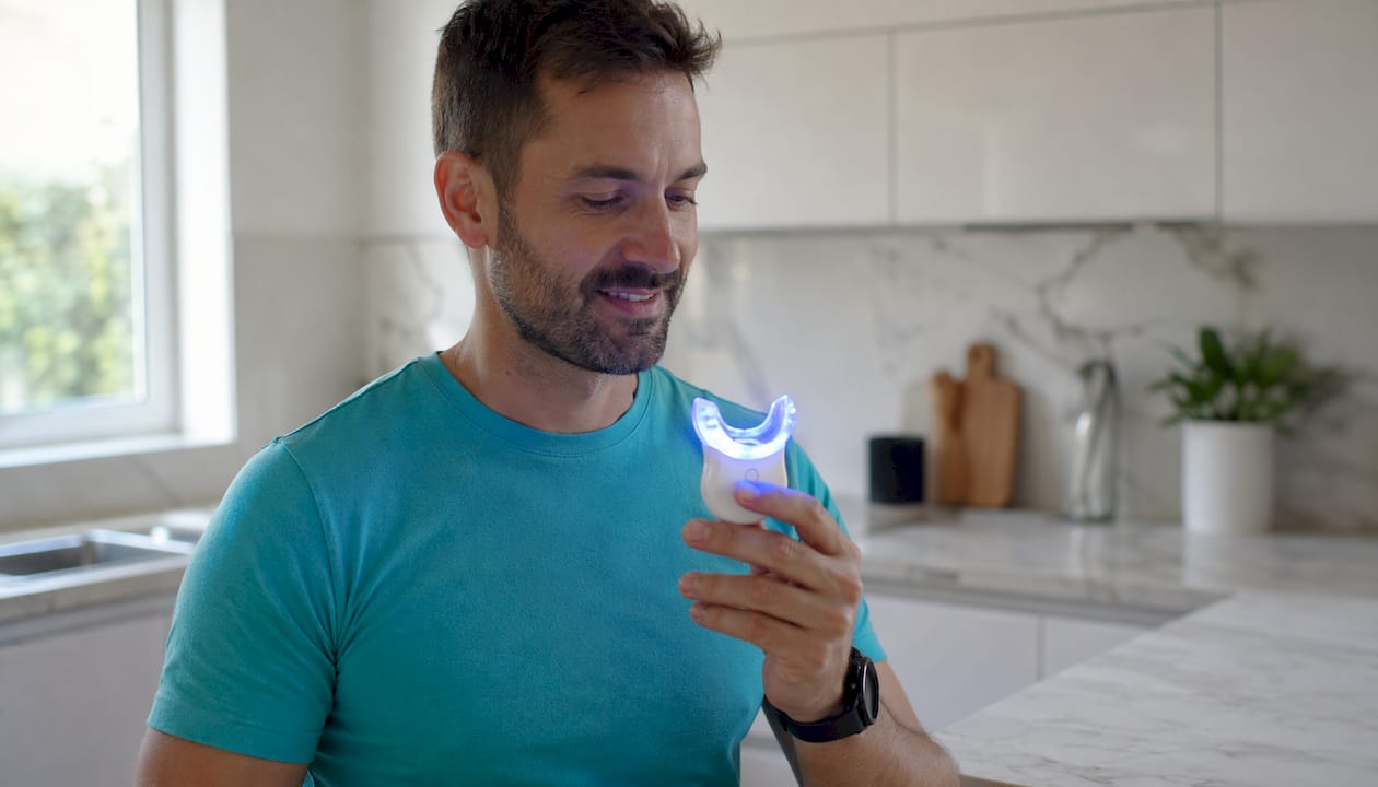 Trattamento sbiancante per denti con mascherina LED applicata manualmente