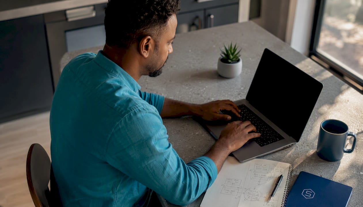 Cloud engineer working on laptop at standing desk