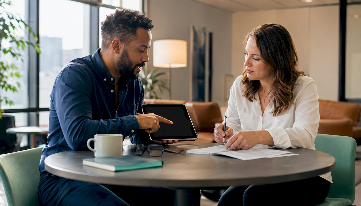 Two agency professionals reviewing milestone documents